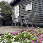 Gården ved sommerhuset. Spiseplads til fire og grill.