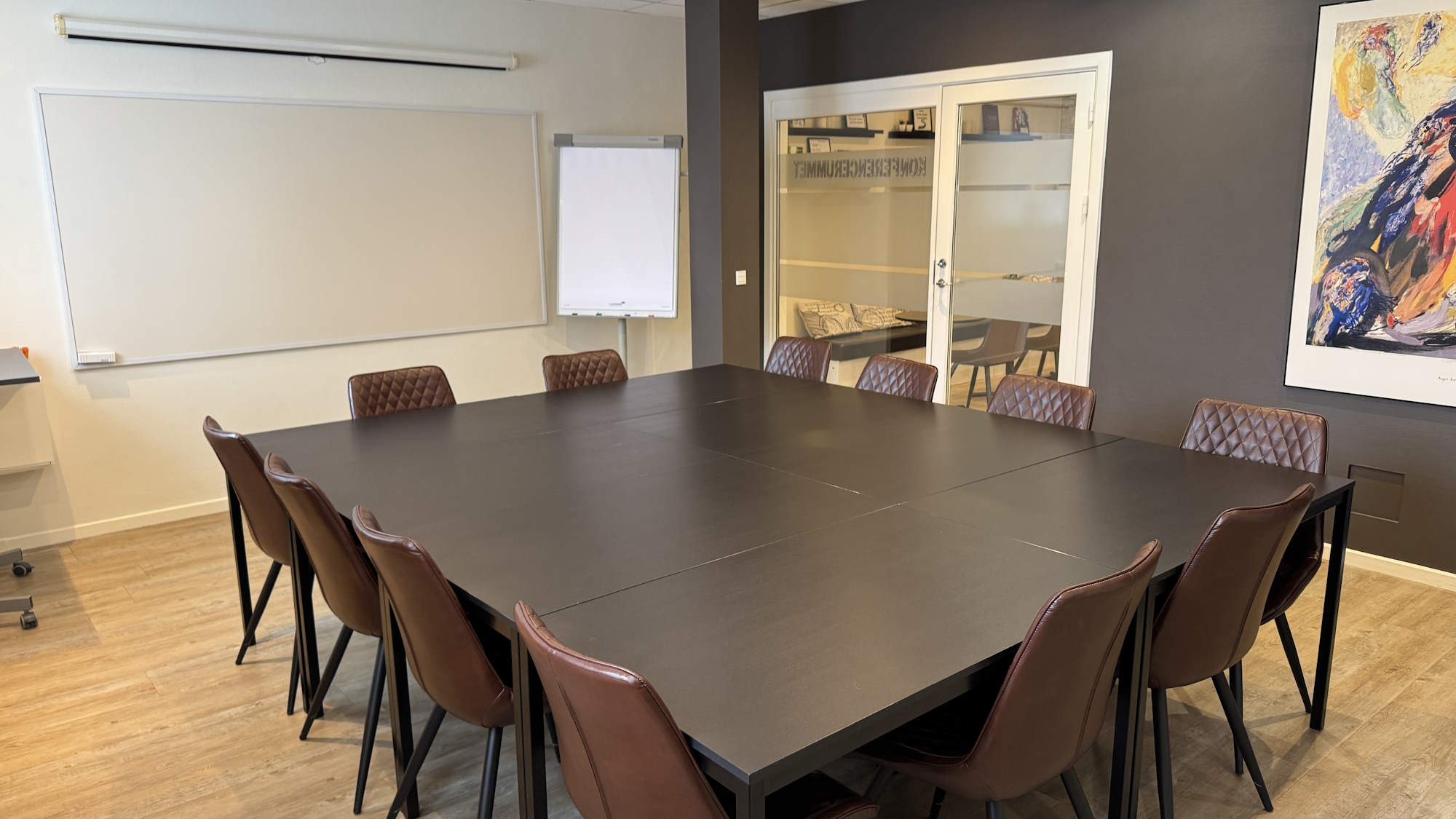 I mødelokalet er der 12 pladser om bordet.